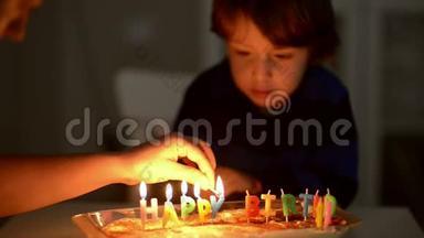 快乐的孩子在他的周年庆典上吹蜡烛
